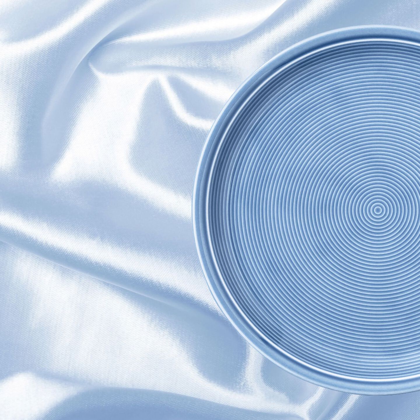 Trend Arctic Blue auf einem HIntergrund, der wie eine hellblaue Seidendecke aussieht