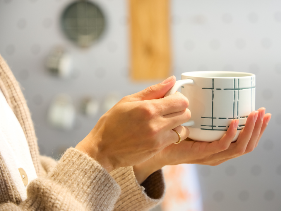 Person holding Thomas mug with modern pattern
