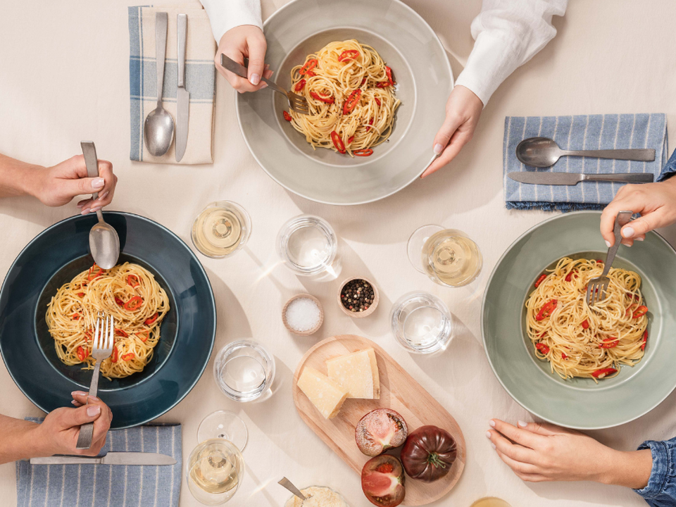 Repas de pâtes convivial sur la vaisselle colorée Thomas Amici