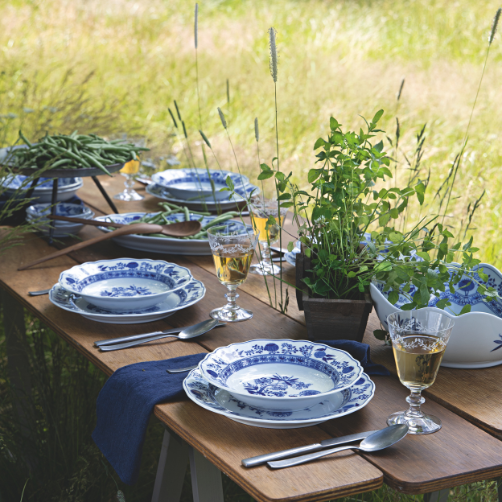 Country-style table set outdoors with blue and white Hutschenreuther porcelain