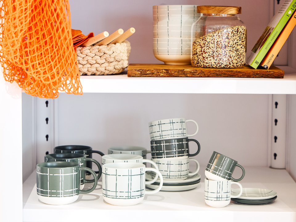 Japandi-style crockery by Thomas, featuring checked cups, plates and bowls on an open kitchen shelf.