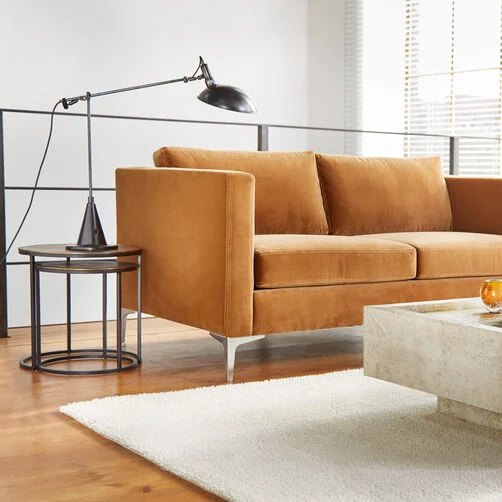 Modern living room with brown velvet sofa, side table and designer lamp