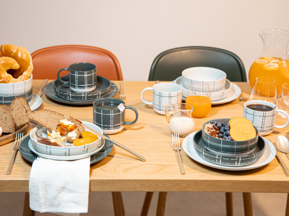 A breakfast table with Japandi-style tableware by Thomas, set with cups, plates, bowls and a variety of breakfast dishes.