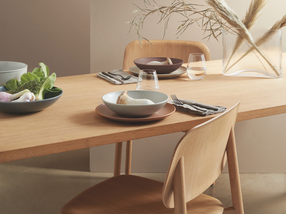 Japandi-style tableware by Thomas on a light wooden table with natural decorations and a minimalist table setting.