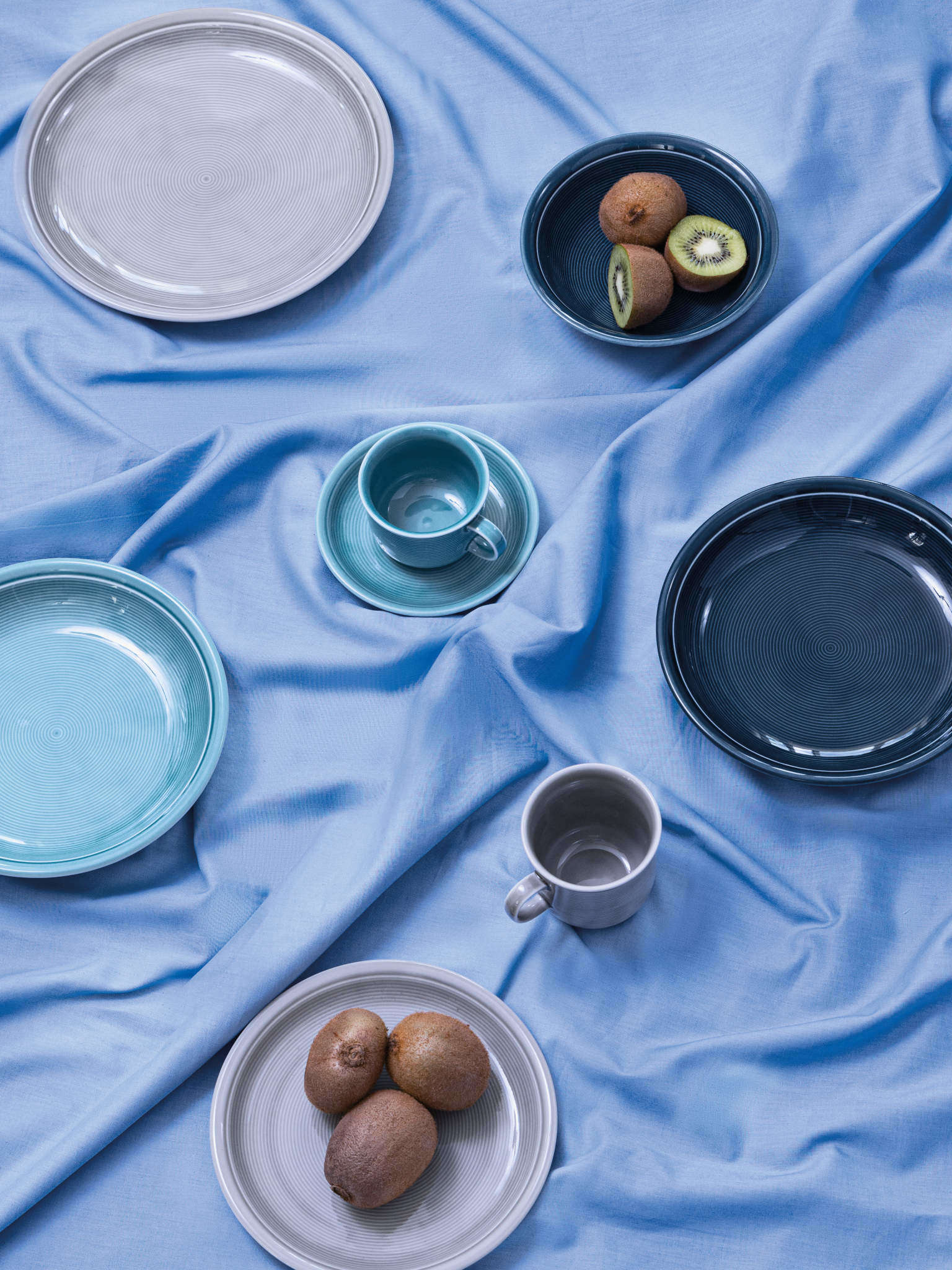 Thomas Trend Porzellanartikel mit Kiwis auf blauer Tischdecke 