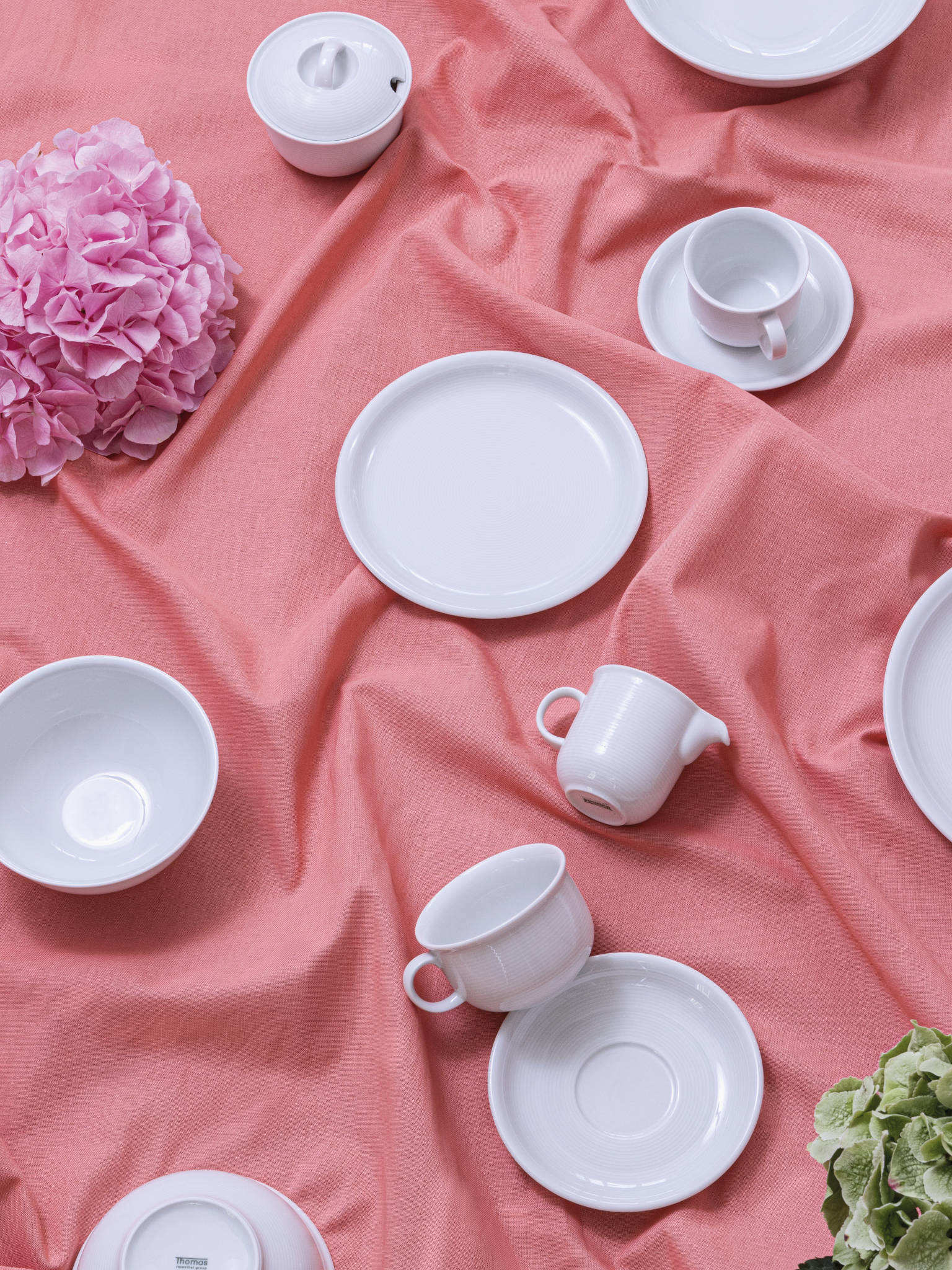 Thomas Trend Weiß Porzellanartikel durcheinander liegend auf rosa Tischdecke