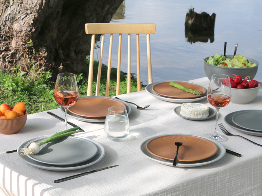 Barbecue table with Thomas tableware by the lakeside in the sun