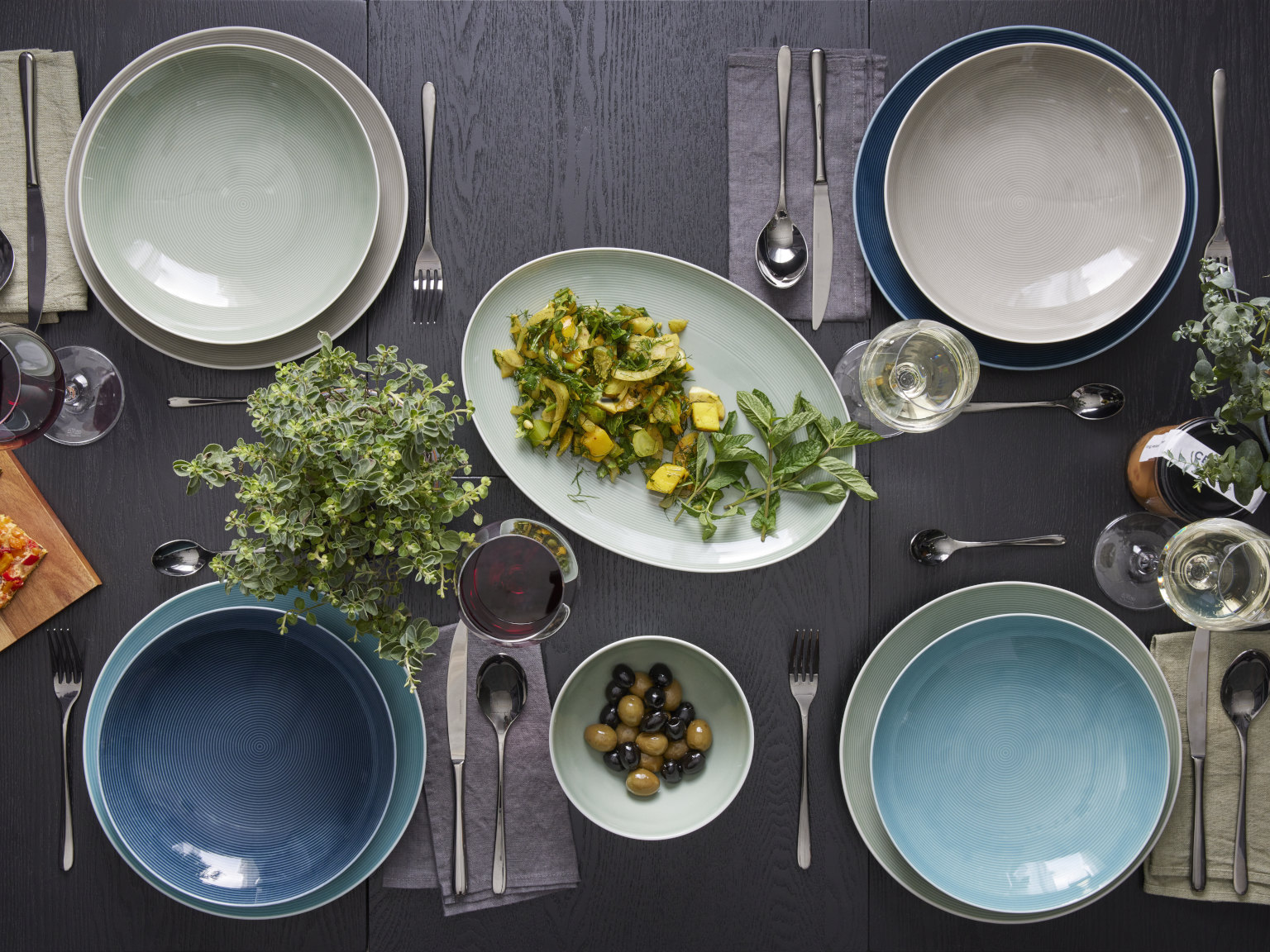 Thomas Loft porcelain collection dark table with different coloured plates & platter with food in the middle