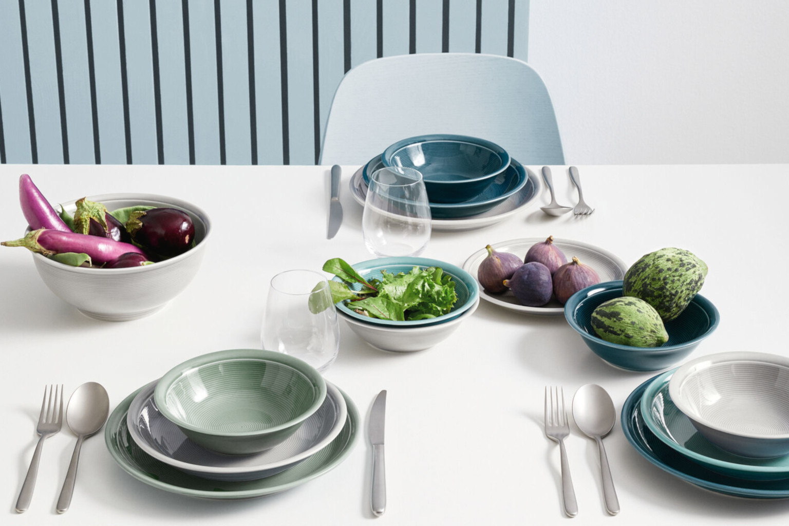 Gedeckter Tisch mit blauen und hellgrünen Thomas Loft Geschirr und Salat und rohem Gemüse als Dekoration