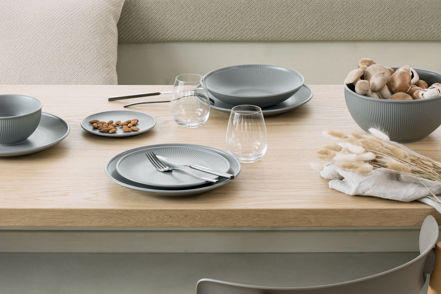 Gedeckter Tisch mit Thomas Clay Smoke Steinzeug-Geschirr mit Mandeln auf einem Teller
