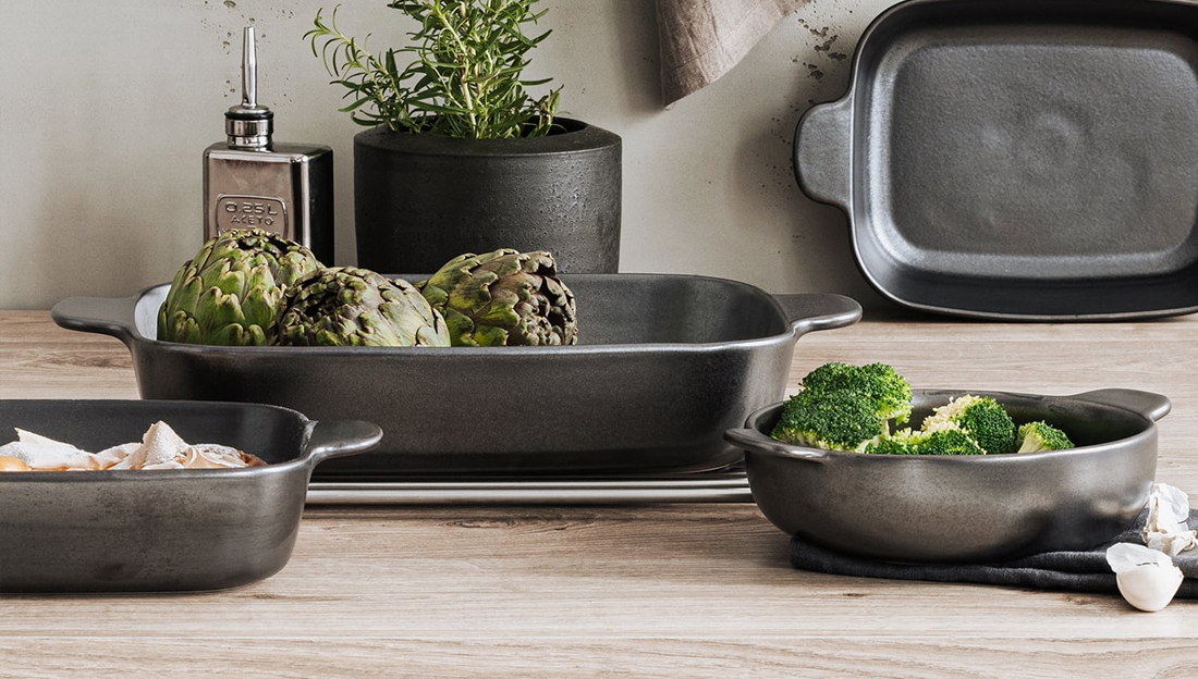 Auflaufformen in unterschiedlichen Größen gefüllt mit Artischocken und Brokkoli in Küchen-Umgebung